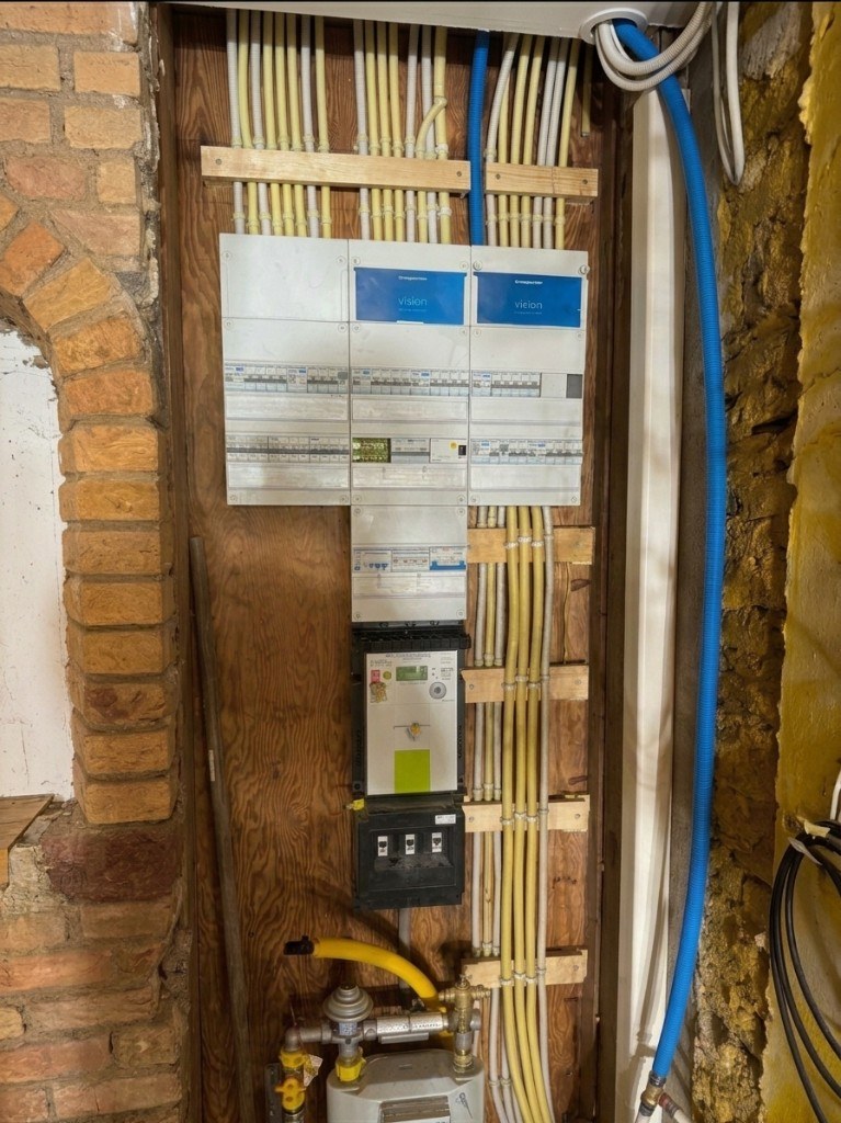 Nieuwe groepenkast en meterkast installatie met gele leidingen