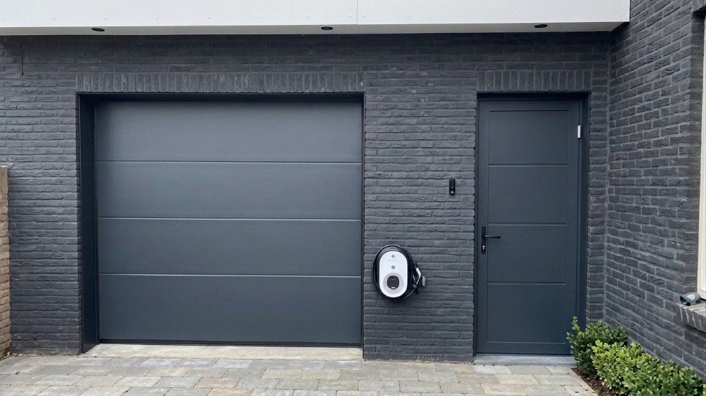 Antraciete sectionale garagedeur met bijpassende zijdeur en laadpaal door Montage Service Limburg