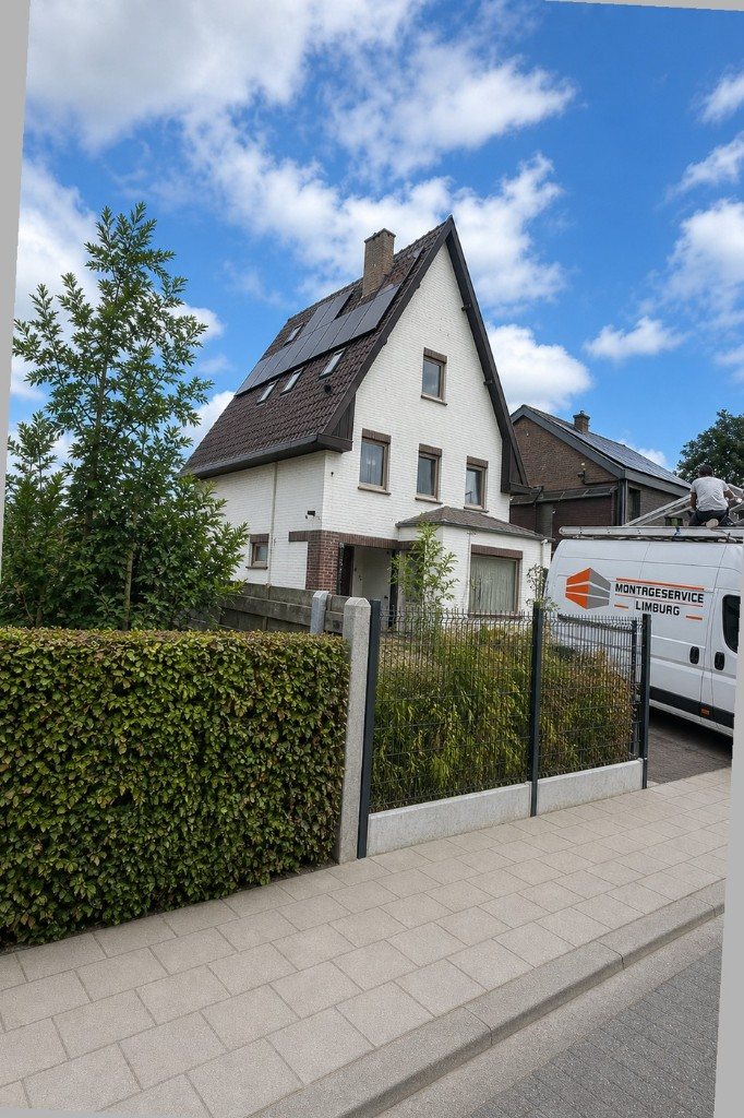 Witte woning met nieuwe donkere kozijnen en Montage Service Limburg bus